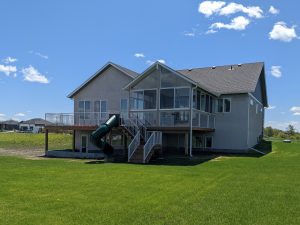 Large sandalwood sunroom with large open deck with a slide! There is a paved walkout basement too.