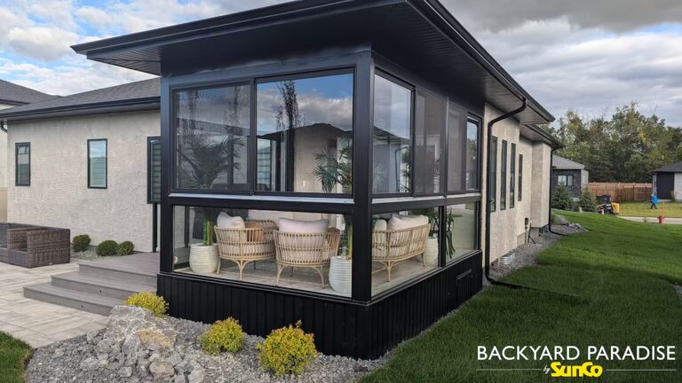 Black structural curtain wall sunroom with composite deck and topless glass rail in Oak Bluff, Manitoba