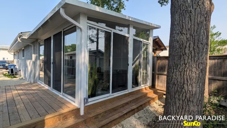 White studio sunroom on a duplex with firewall and brown treated deck in Windsor Park, Winnipeg