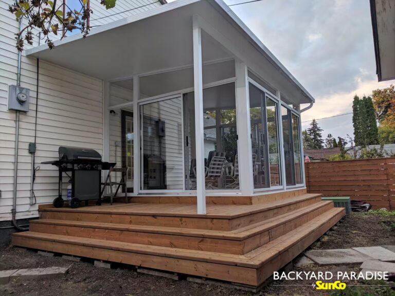 White studio sunroom with wrap around stadium staircase and covered deck in River Heights, Winnipeg